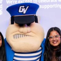 Two grads smile with Louie